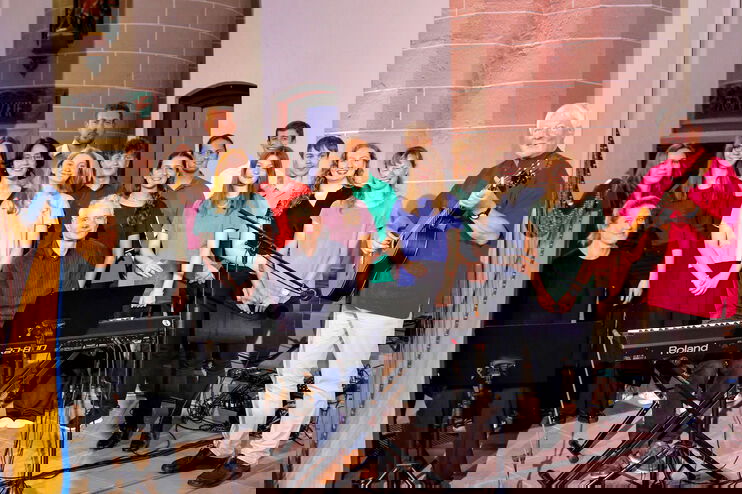 Ein Chor mit einer Harfenistin, einem Pianisten und einem Gitarristen.