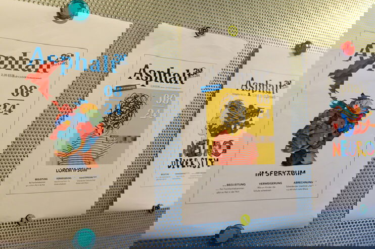 Cover des Straßenmagazins Asphalt pinnen an einer Wand.