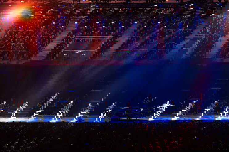 Mehrere Menschen stehen mit den Buchstaben BETHLEHEM auf einer Bühne, im Hintergrund sind viele Menschen zu sehen.