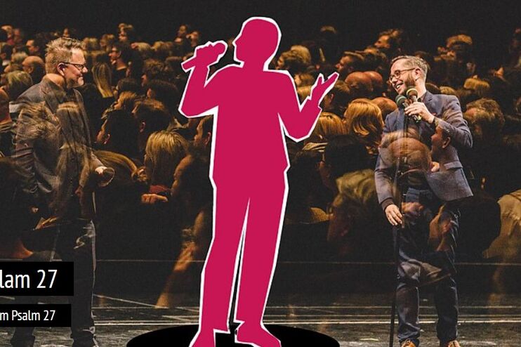 Eine rosane, nur umrissene Person steht vor einem großen Publikum.