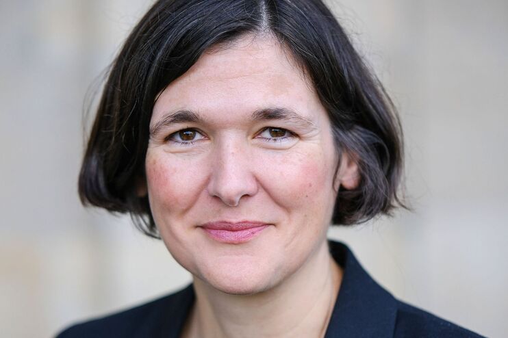 Eine weiblich gelesene Person mit kurzen schwarzen Haaren.