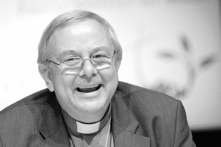 Eine mittelalte als Mann lesbare Person mit Brille und im Kollarhemd