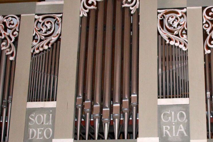 Orgelpfeifen, darunter steht Soli Deo Gloria