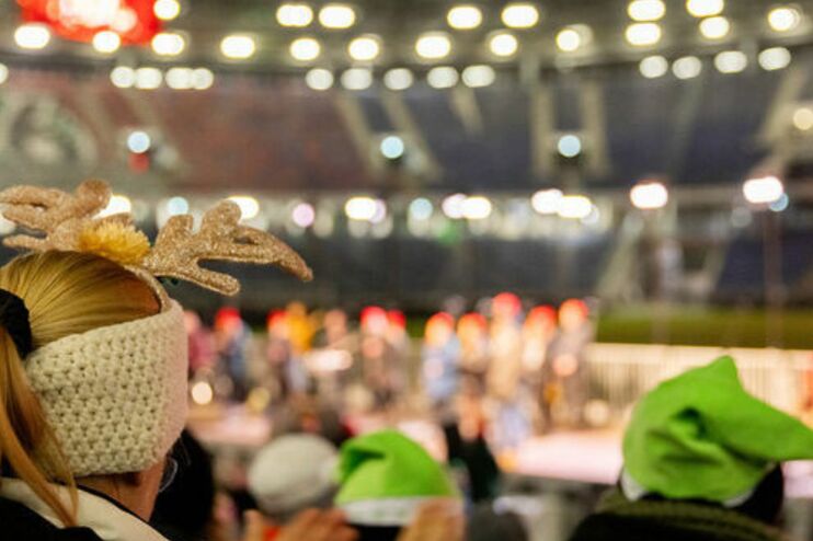 Menschen stehen in einem Fußballstadion.