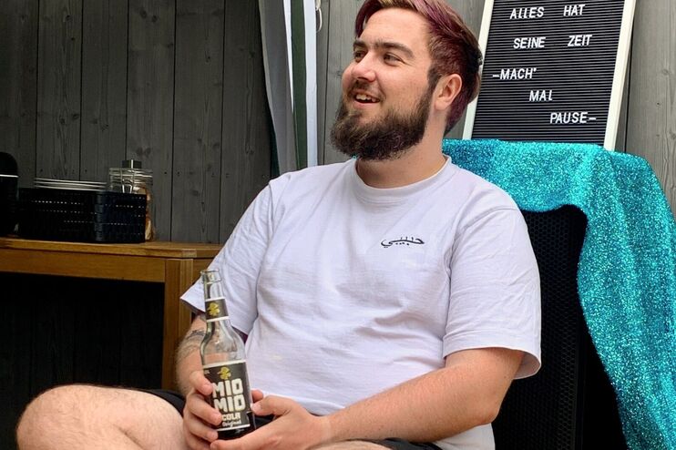 ein Mann in einem Liegestuhl mit einer Limo in der Hand