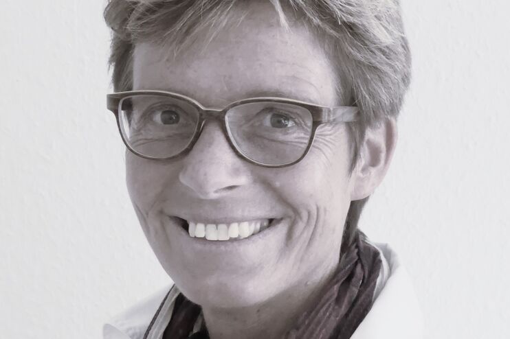 Schwarzweiß-Foto einer als Frau lesbaren Person mit Brille und kurzen Haaren.