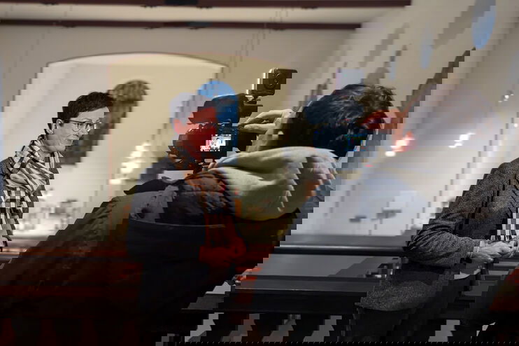 Eine als Frau lesbare Person gibt ein Interview und wird dabei gefilmt.