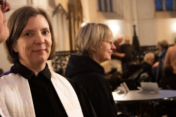 Eine weiblich gelesene Person steht in einem Ornat in der Kirche.