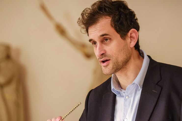 Eine männlich gelesene Person vorm Rednerpult