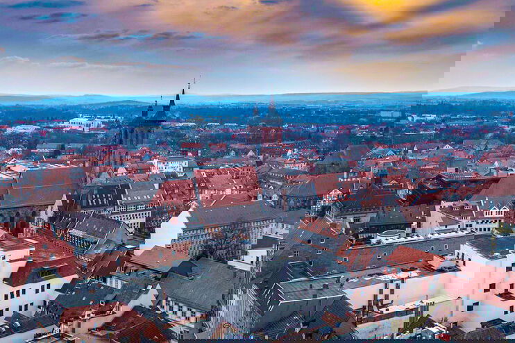 Eine Stadtansicht mit einer Kirche in der Mitte vor dramatischem Abendlicht