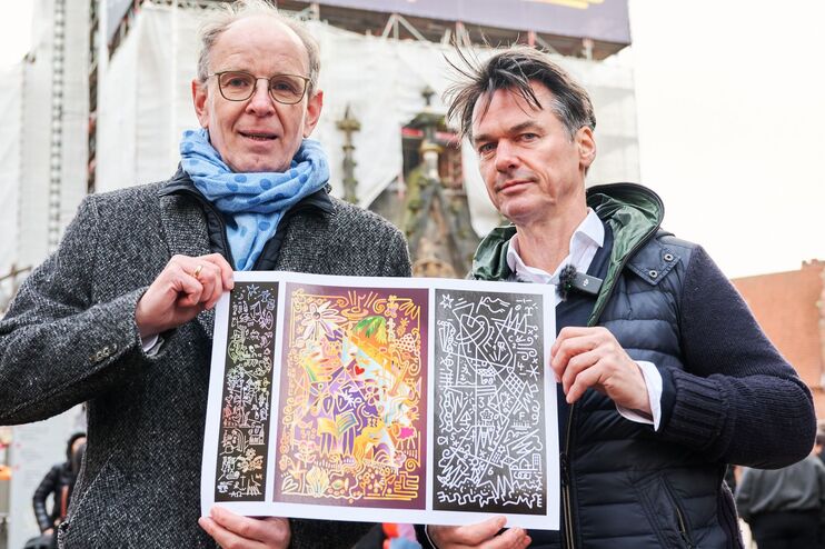 Zwei männlich gelesene Personen halten ein Gemälde.