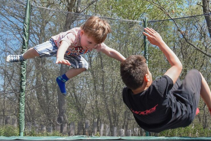 Zwei Kinder hüpfen auf einem Trampolin