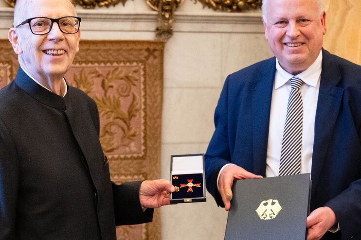 Zwei Männer im Anzug halten eine Auszeichnung.