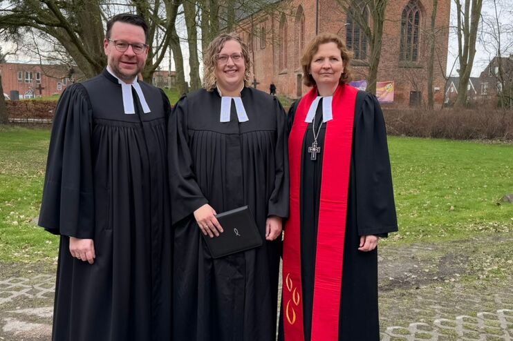 Zwei weibliche und eine männliche Person im Talar.