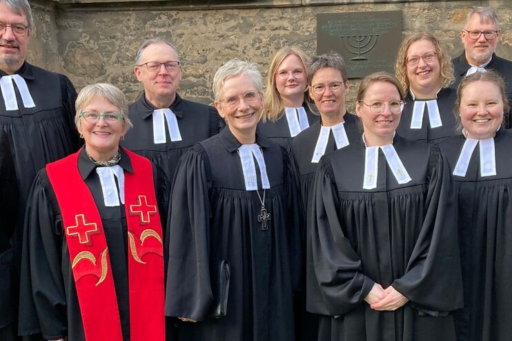 Eine Frau steht vor einer Mauer.