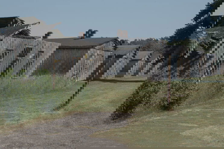 Holzbaracken eines ehemaligen NS-Kriegsgefangenenlagers.