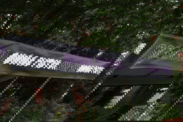 Auf einem schwarzen Sonnenschirm eines Lastenrades steht "Reden ohne Filter, Kirche ohne Filter"