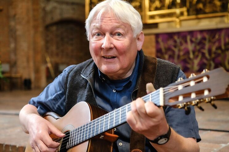 Ein älterer Mann spielt auf einer Gitarre.