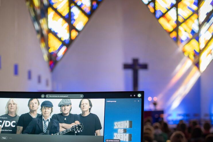Eine Kirche auf einem Laptop sieht man eine ACDC-Playlist.
