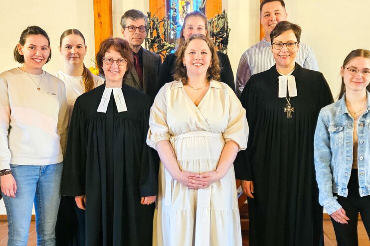 eine Gruppe von MEnschen in einer Kirche schaut in eine Kamera