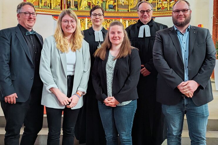 eine Gruppe von Menschen vor einem Kirchenaltar