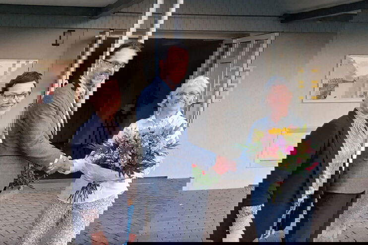 Eine als Mann lesbare Person nimmt Glückwünsche zweier als Frauen lesbare Personen entgegen.