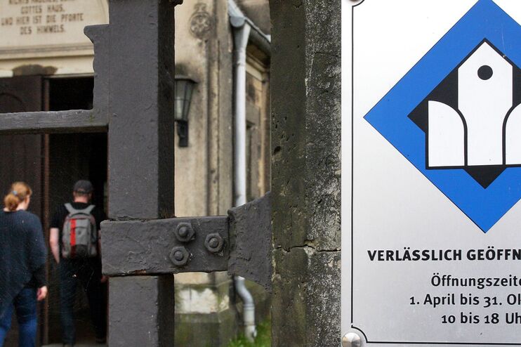 ein Schild mit Kirchensymbol neben einer Eingangstür