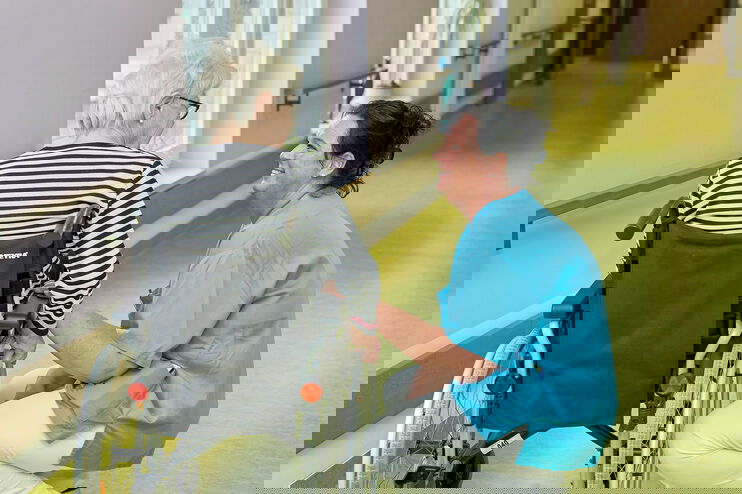 Pflegekraft mit einer Bewohnerin in einem Pflegeheim.