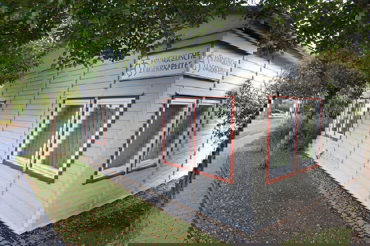 Ein weißes Gebäude mit der Aufschrift Evangelische Lagerkapelle