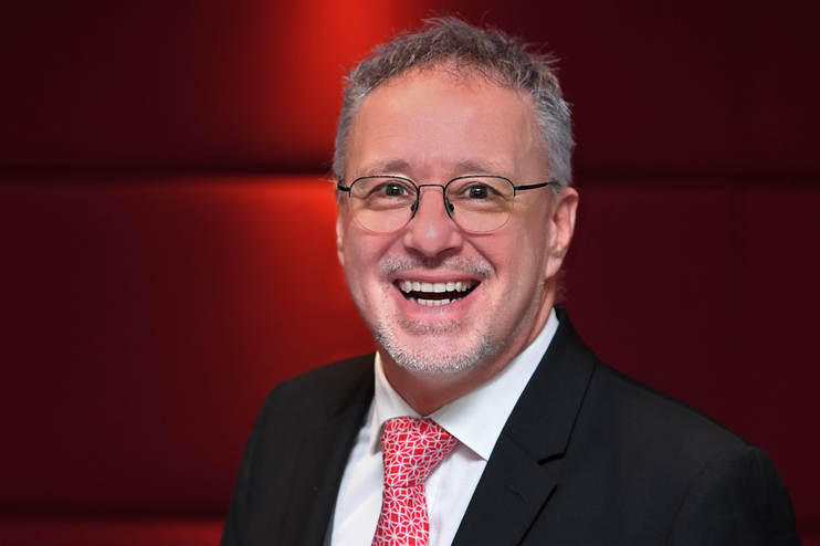 Ein Mann im Anzug mit roter Krawatte.