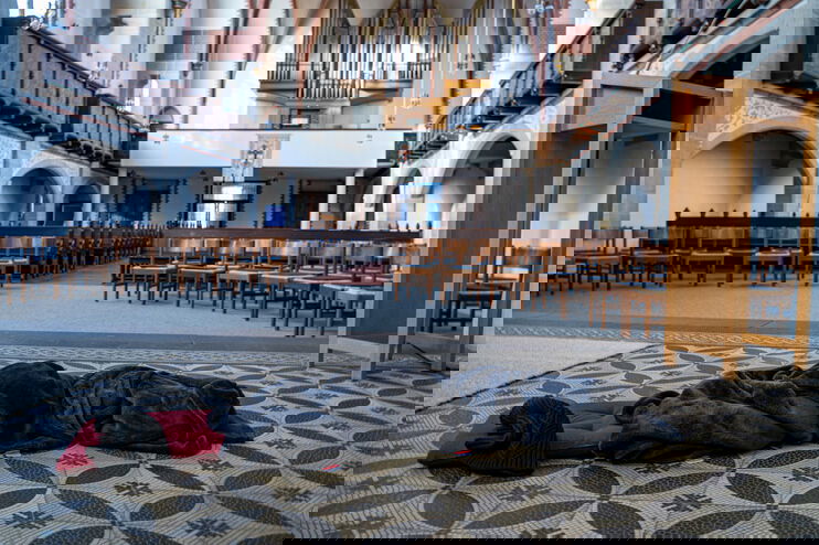 Ein Schlafsack liegt im Altarraum einer Kirche.