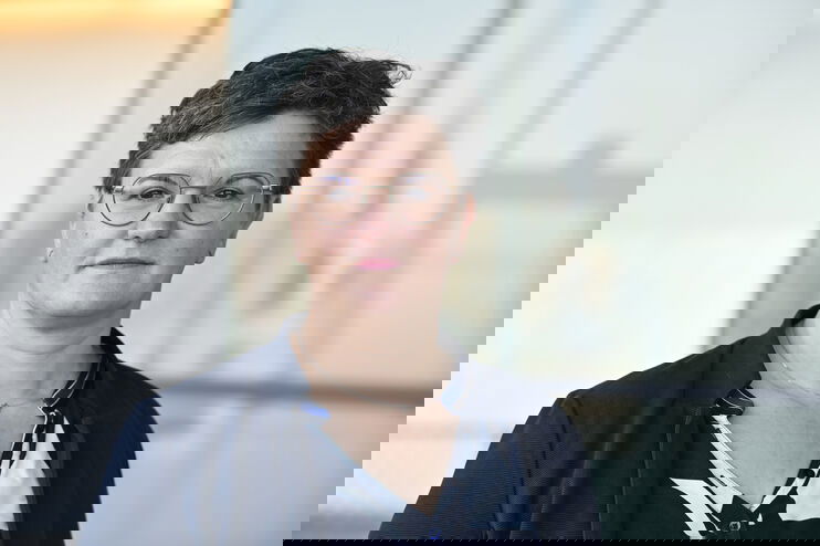 Portraitfoto einer als Frau lesbaren Person mit kurzen Haaren.