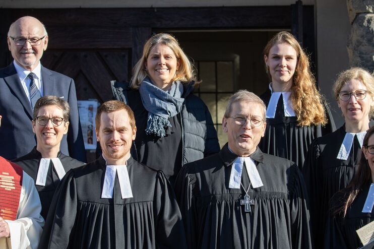 Menschen in Festkleidung vor einer Kirche.