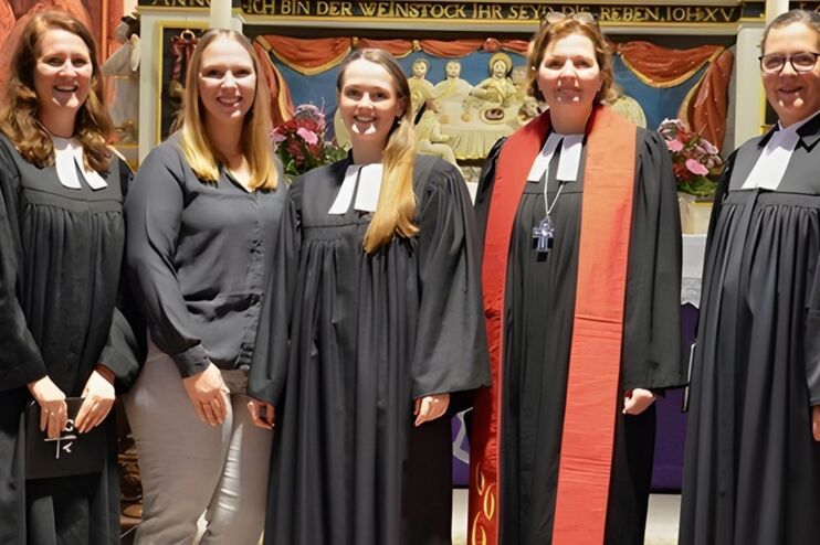 Frauen im Ornat vor einem Altar.