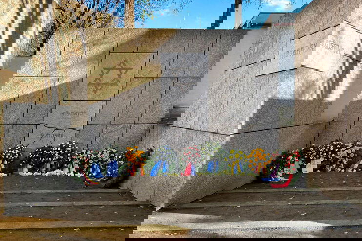 Ein Mahnmal für die Opfer der Judenverfolgung mit Kränzen davor