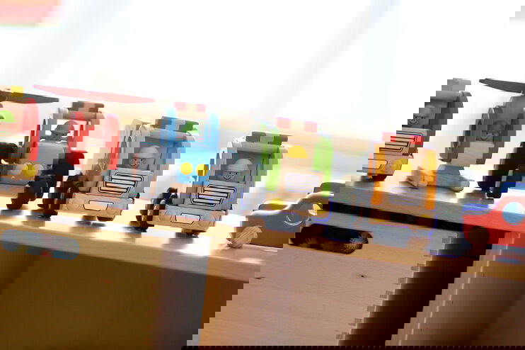 Aufgereihte Holzautos für Kleinkinder