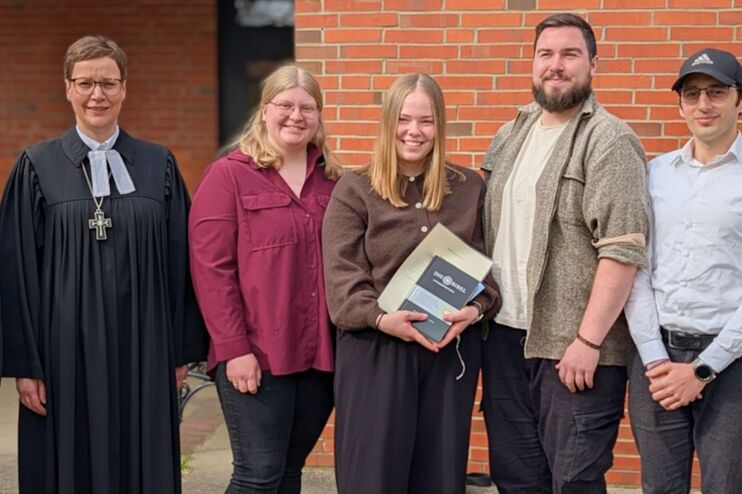Menschen in Festtagskleidung vor einer Kirche.