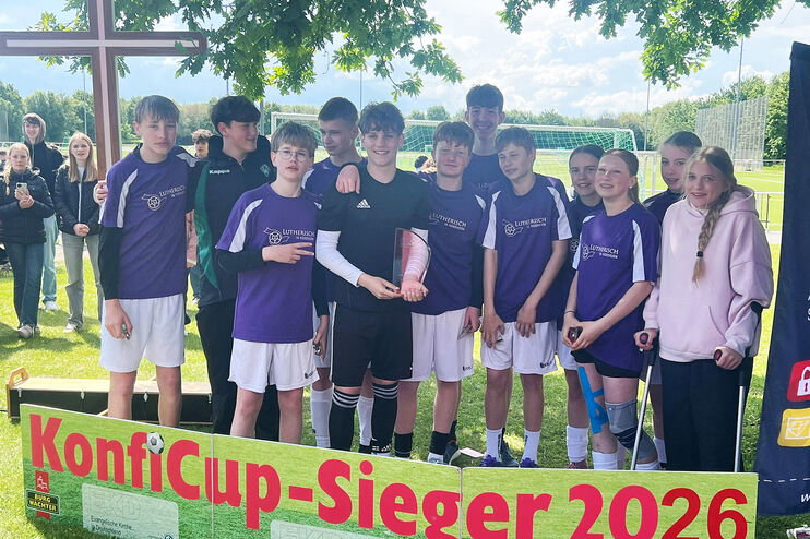 Eine Fußballmannschaft steht hinter einem Banner mit der Aufschrift KonfiCup-Sieger 2026.