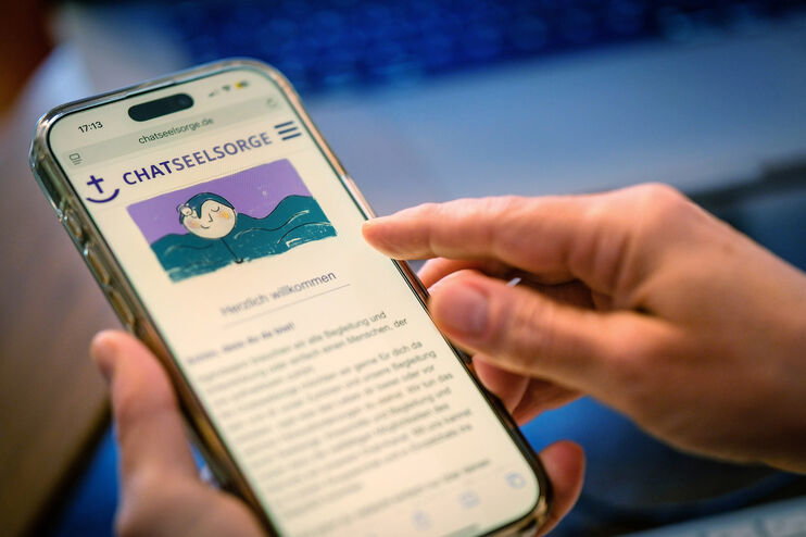 Eine Person schaut sich die Seite der Chatseelsorge auf dem Smartphone an