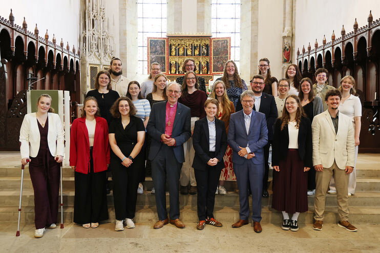 Eine größere Gruppe junger Menschen steht im Altarraum einer Kirche.