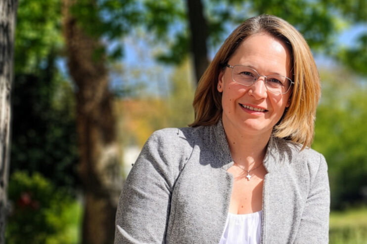 Eine als Frau lesbare Person im Grünen