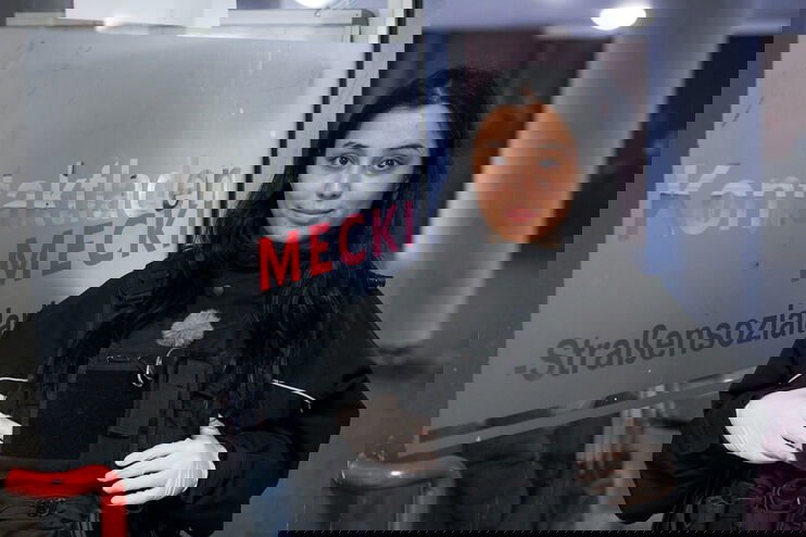 Eine junge Frau in Uniform lächelt verhalten in die Kamera.