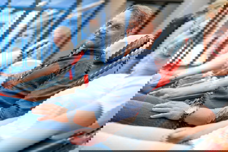 Drei Personen liegen nebeneinander und haben Schläuche in den Ellenbogen, zum Blutspenden. Sie lächeln. 