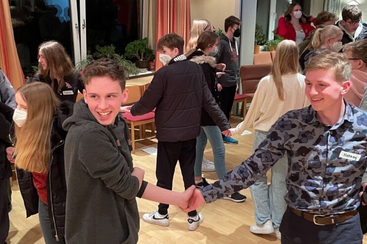 Eine Guppe Jugendlicher tanzt fröhlich.