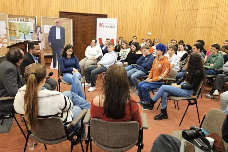 Mehrere junge Menschen sitzen in einem Raum auf Stühlen.