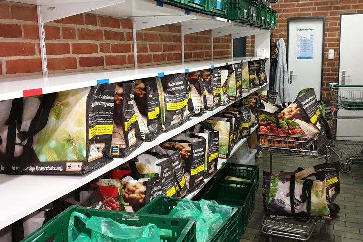 In Regalen an einer Wand stehen Tragetaschen.