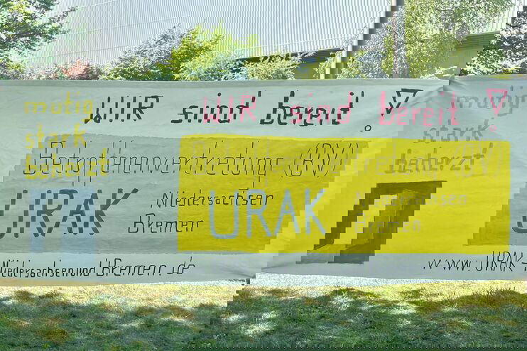 Ein Plakat an einem Zaun mit den Worten: URAK - wir sind bereit! Mutig, stark, beherzt