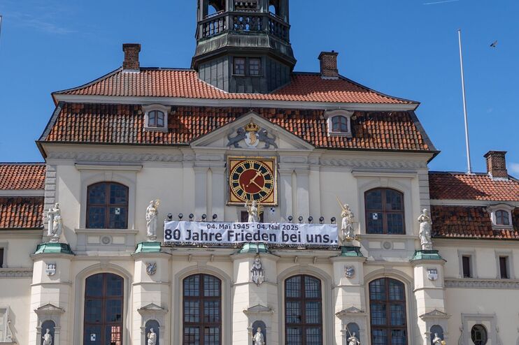 Ein Gebäude, an dem ein Banner hängt, auf dem steht: 80 Jahre Frieden bei uns (4. Mai 1945 bis 4. Mai 2025).