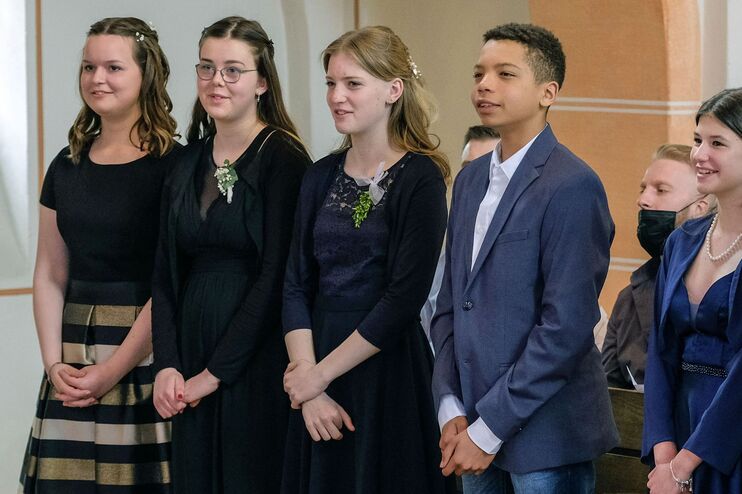 Ein Gruppe Jugendlicher in Kleidern und Anzügen