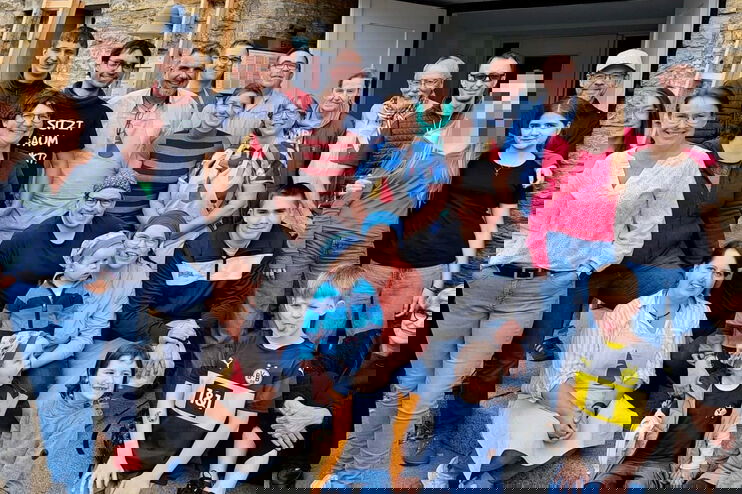 Eine altersmäßig bunt gemischte Gruppe vor einer Kirche